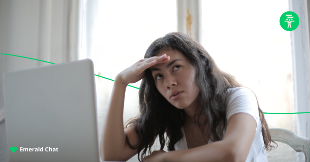 photo of a female in front of her laptop, holding her forehead and looking confused